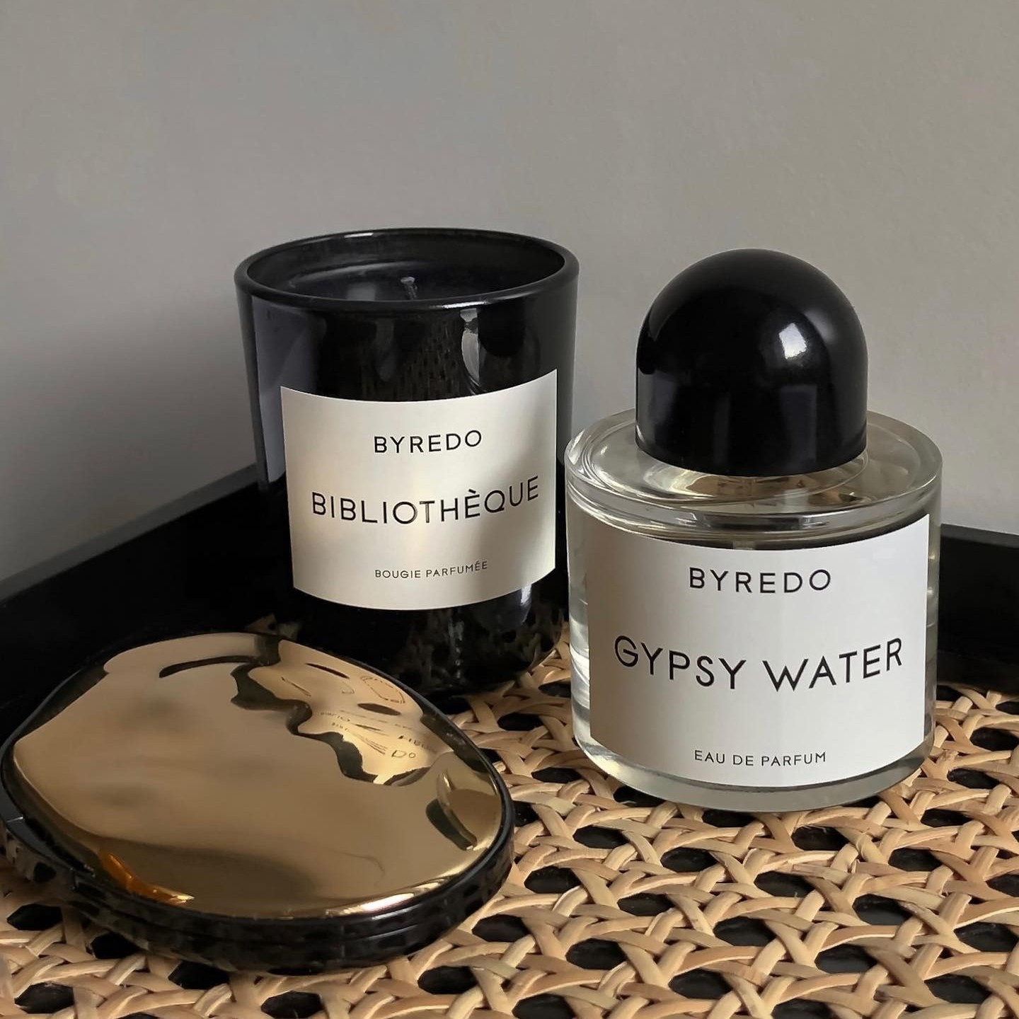 Photo of a Byredo fragrance, candle, and eye shadow palette on a table