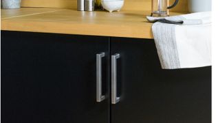 black kitchen units with vinyl wooden worktop