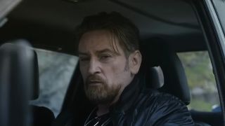 Beno&icirc;t Magimel sitting in a car in The Hunt