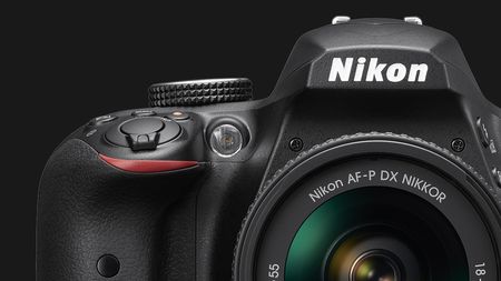 Close-up of a Nikon D3500 DSLR camera, highlighting the logo, controls, and lens, set against a black background