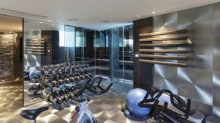 A stylish home gym with stainless steel walls and floors