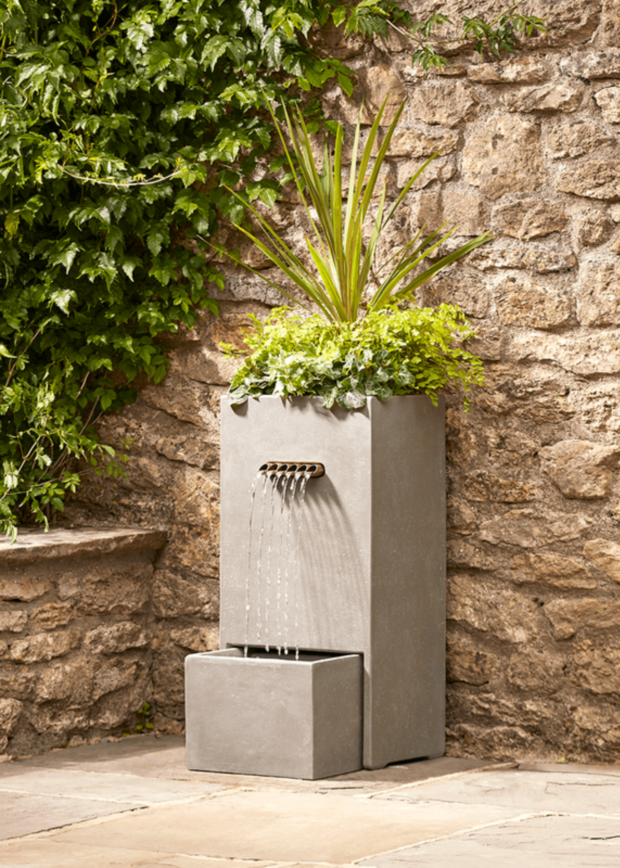 An industrial-style outdoor water feature with a planter