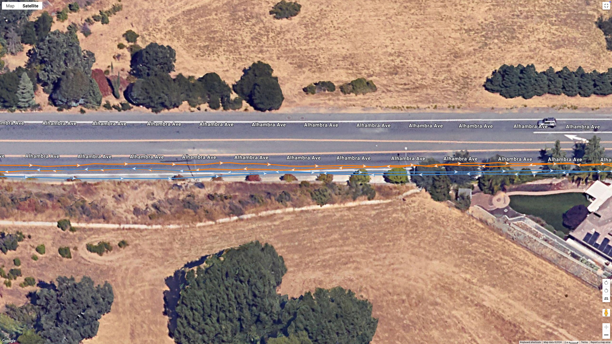 A Google Earth satellite image showing GPS lines for the COROS PACE Pro (blue) and Garmin Fenix 8 (orange) to test their dual-band GPS accuracy.