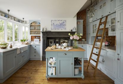 blue-kitchen-with-traditional-aga-ladder-flowers-wood-floors