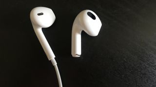 one EarPods and one AirPods 3 earpiece side by side on black background