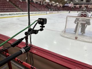 A mini Marshall camera is position behind the net in a hockey arena.