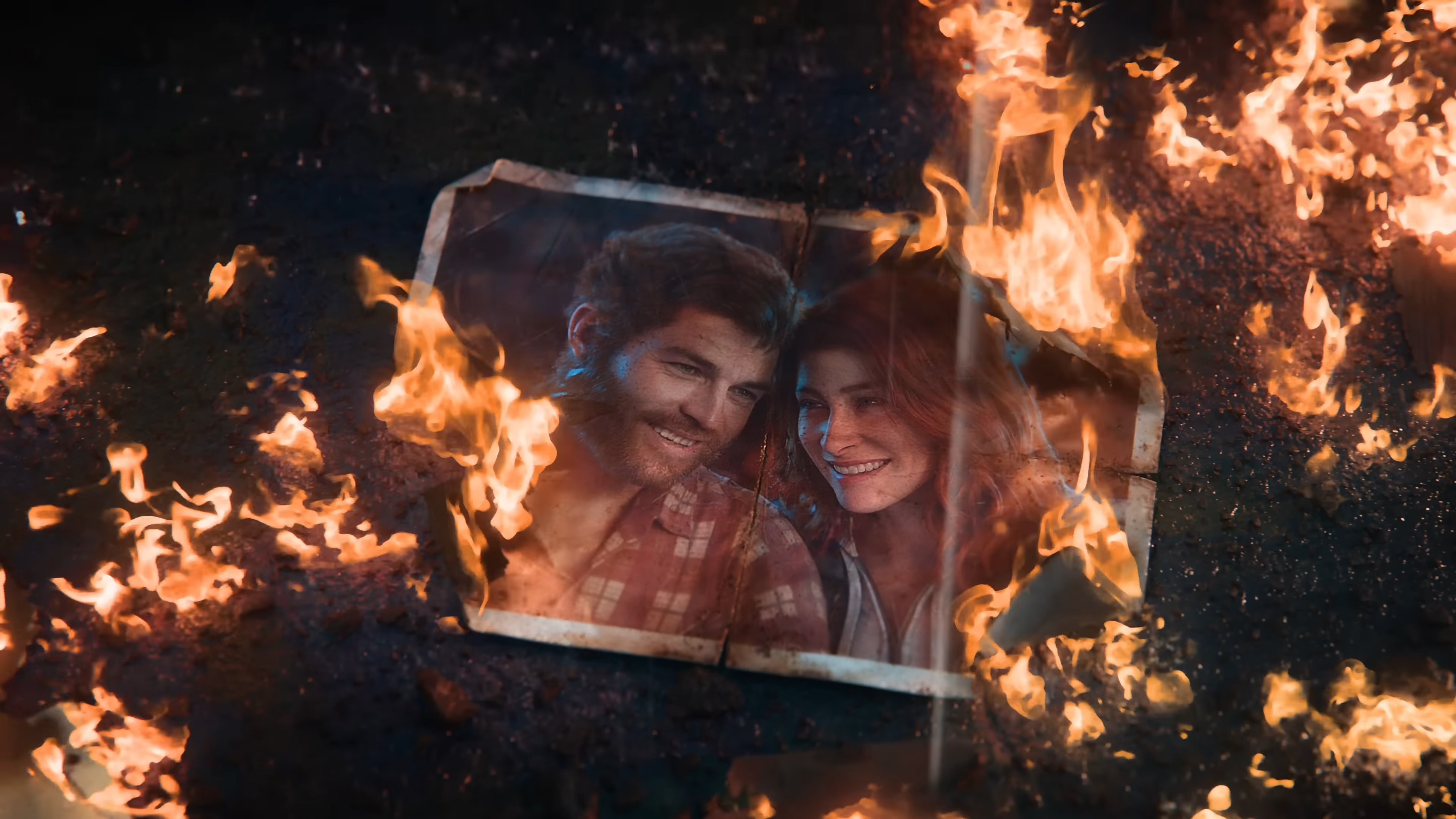 A partially burned photograph of a smiling couple surrounded by flames, with dark ground visible beneath.