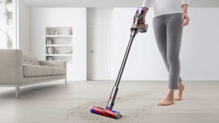 Dyson Micro 1.5kg being used to suck up crumbs on a lounge hard wood floor
