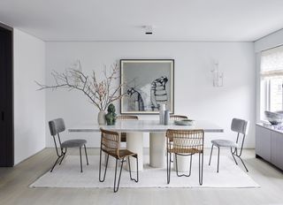 A dining room with grey chairs and wooden chairs