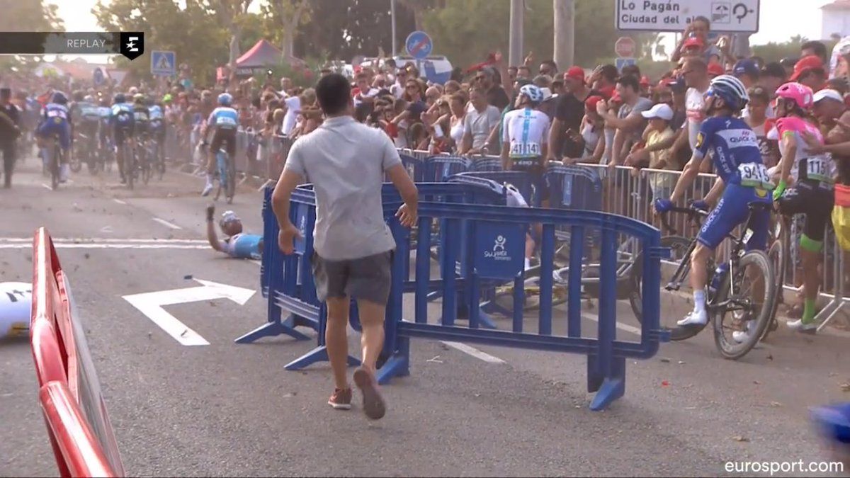 A member of the Vuelta a Espana organisation runs to remove barriers