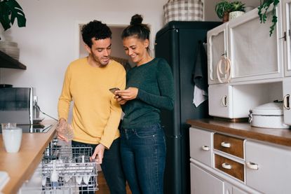 Man and woman looking at a phone, finding out how to save money on electric bills