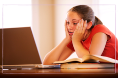 girl sat at computer doing homework