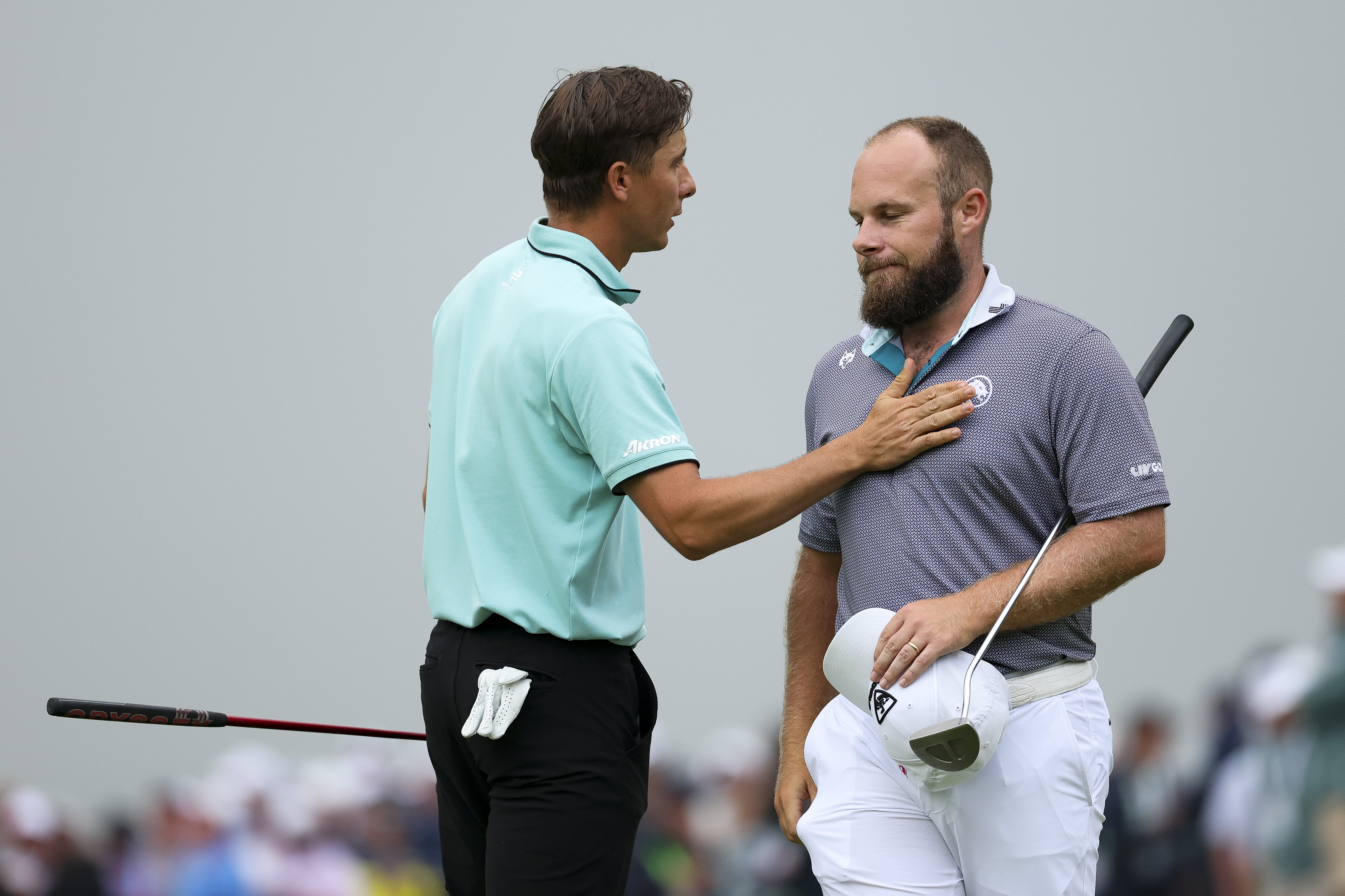 Carlos Ortiz and Tyrrell Hatton walk off the green