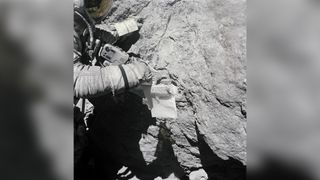 Astronaut Charles M. Duke Jr., lunar module pilot, takes samples and investigates a large lunar boulder at North Ray Crater.
