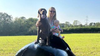 Victoria sitting on hay bale with Maple and son, Arthur