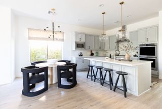 white kitchen with layered lighting and black seating by Living with Lolo