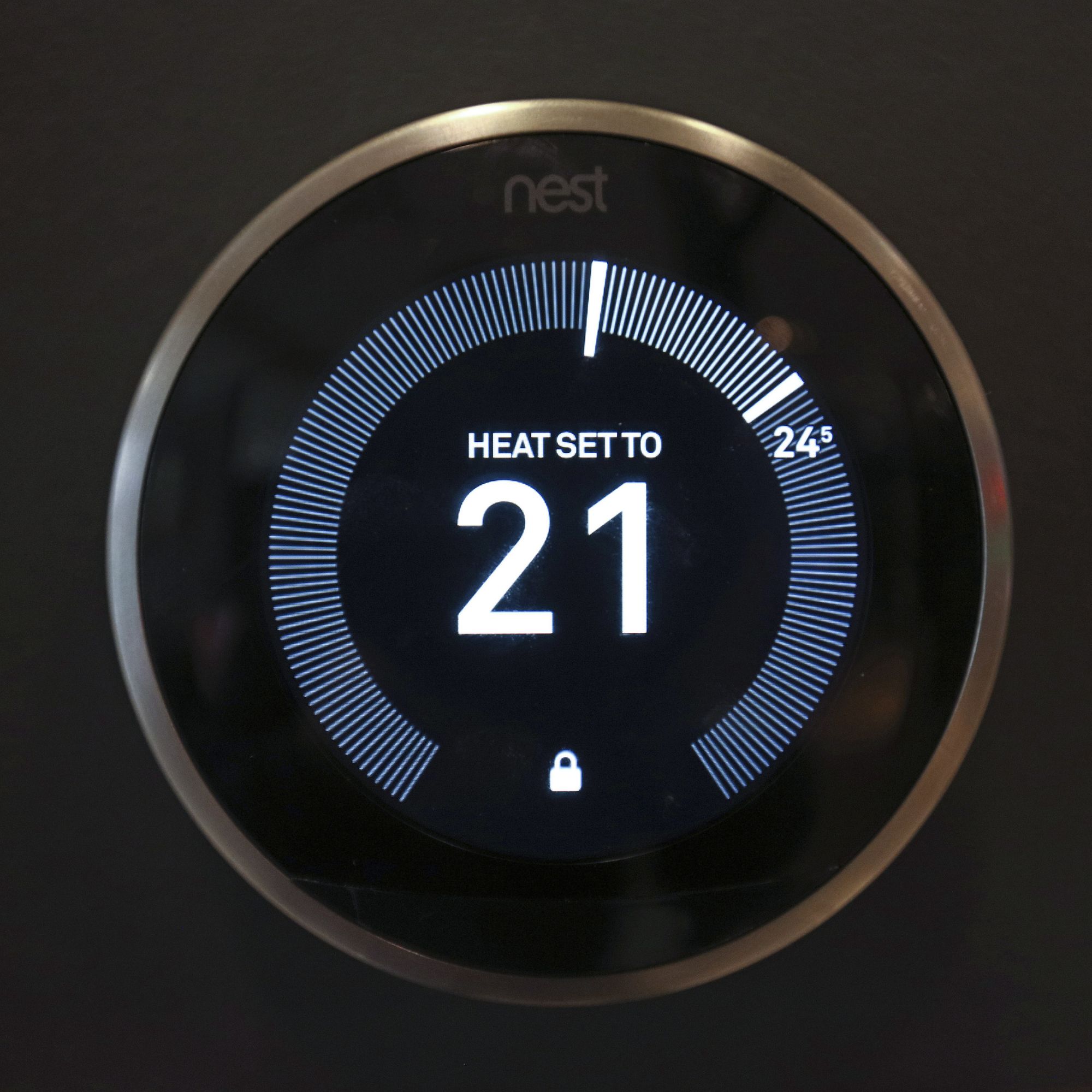 Nest smart thermostat on a black wall