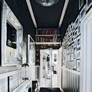 mirror and pictures on wall with book shelves and blue carpet