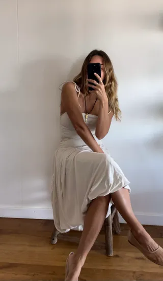 Angie wears a white Free People dress and mesh shoes