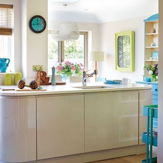 kitchen with smart mix of cream hi-gloss units with blue and green accents