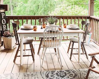 Porch with wooden dining table and chairs, porch sign and plant - @mistymorning_