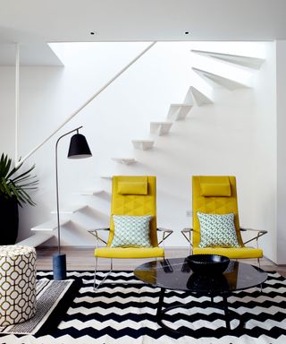 White room, floating steps, yellow armchairs, black and white zigzag rug