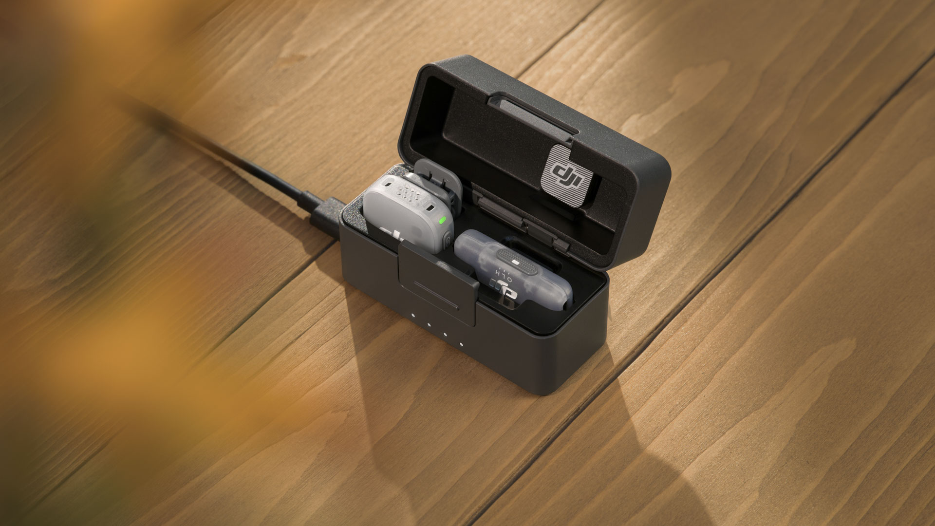 DJI Mic Mini 2 mobile bundle in the charging case on a wooden table