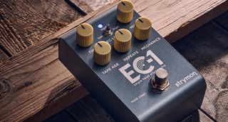 Strymon EC-1 Single Head dTape Echo: the metallic gray box has cream dials, an LED that lights up blue and/or red, and is photographed here against a wooden background.
