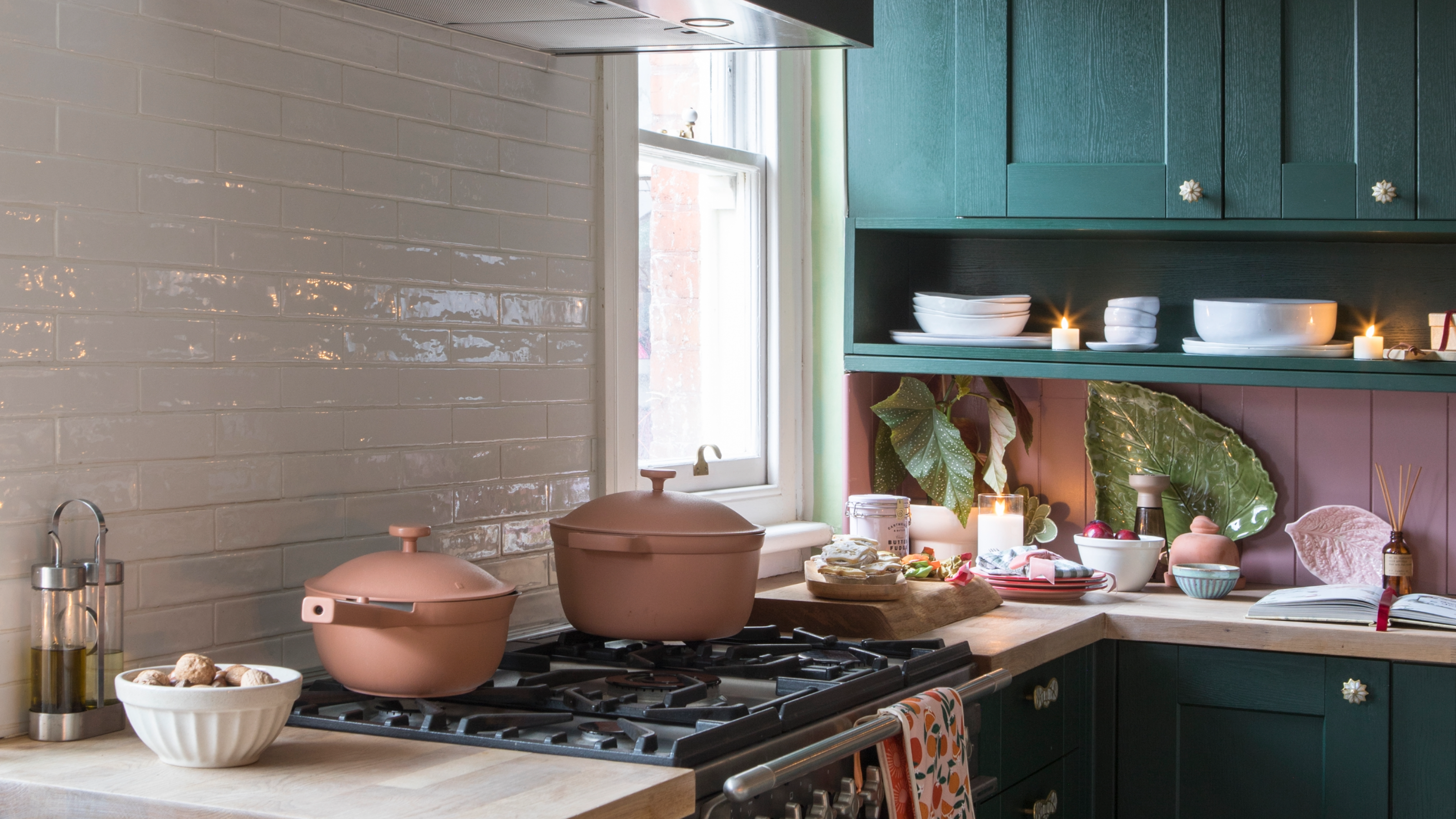 Two pink Always Pans from Our Place on hob in green and pink kitchen 
