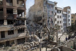 An excavator removes debris from a residential building that was destroyed in today's attack by Israel in Tehran, on June 13, 2025 in Tehran, Iran. Early this morning, Iran was hit by a series of Israeli airstrikes targeting military and nuclear sites, as well as top military officials. Majid Saeedi/Getty Images