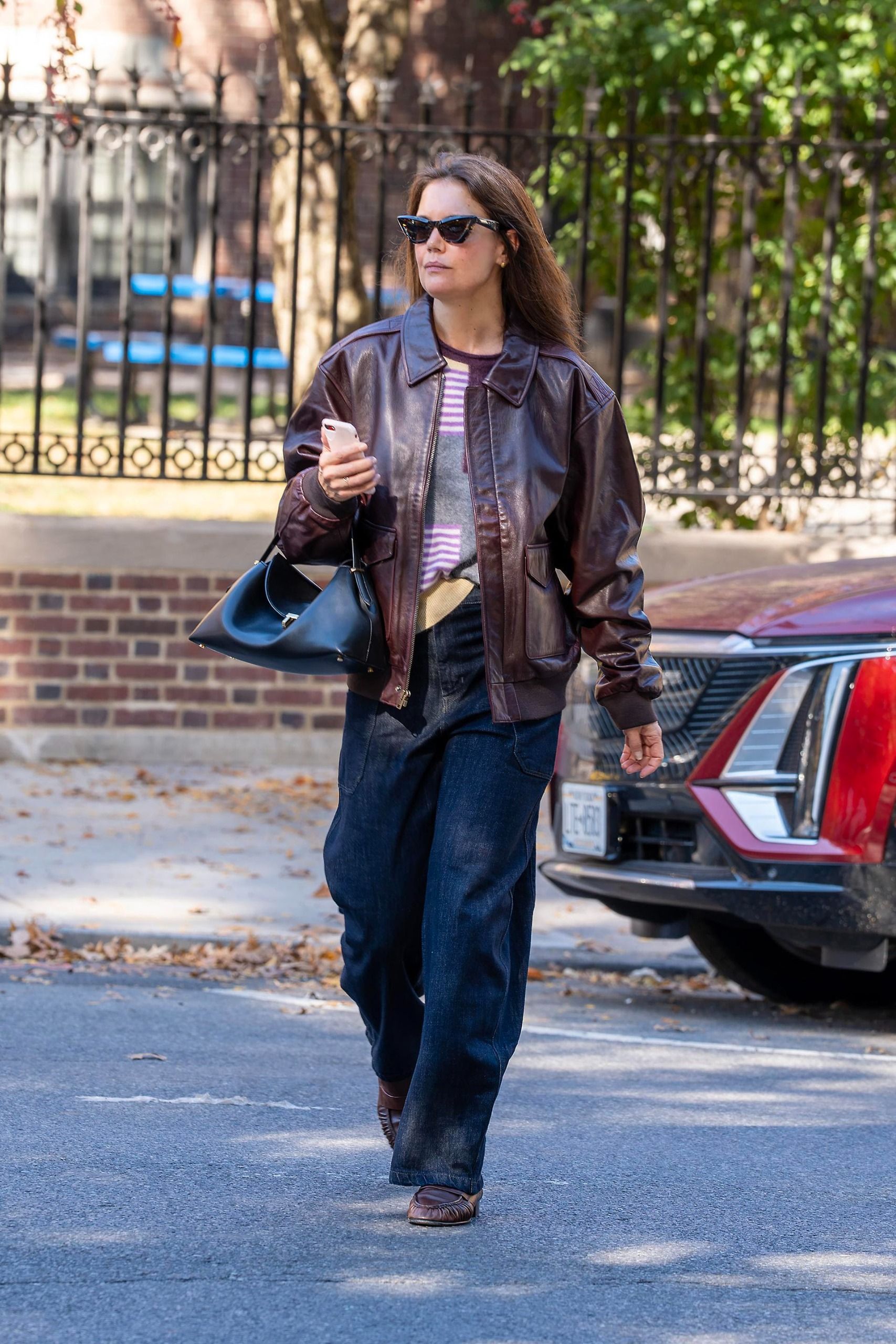 Katie Holmes wears a burgundy leather jacket by Banana Republic along with barrel jeans and loafers