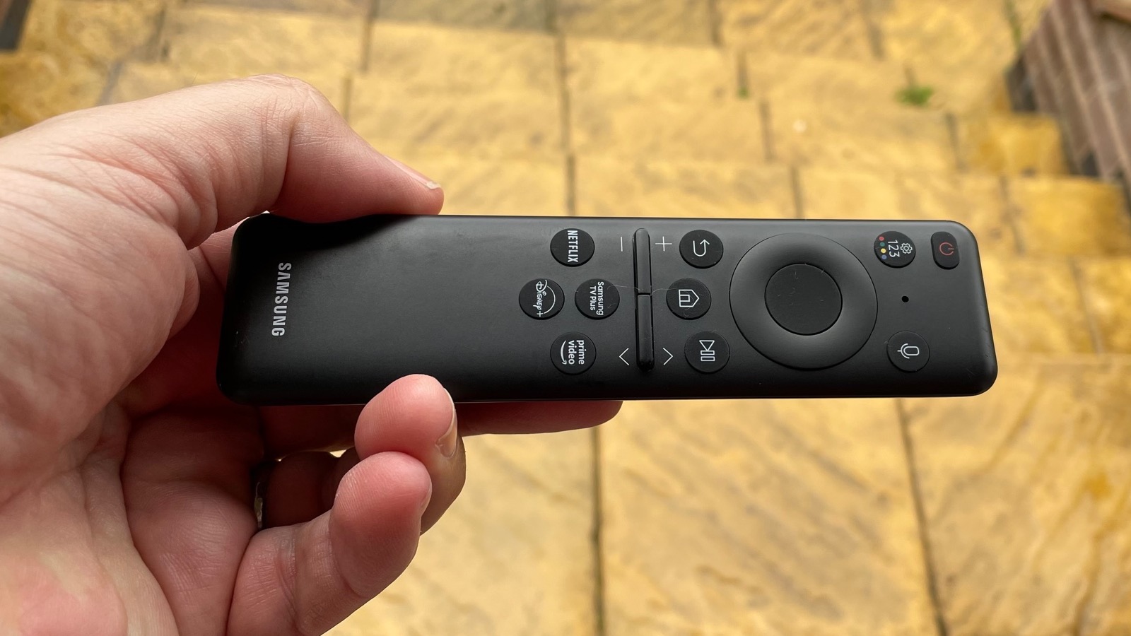 Samsung S90C remote held in a hand
