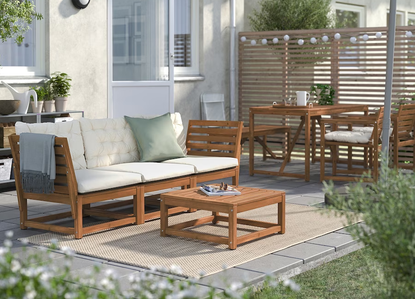 A backyard with outdoor furniture on a small patio