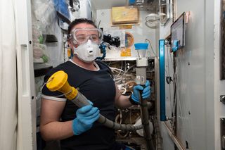 NASA astronaut Serena Auñón-Chancellor does maintenance on the current U.S. space station toilet.