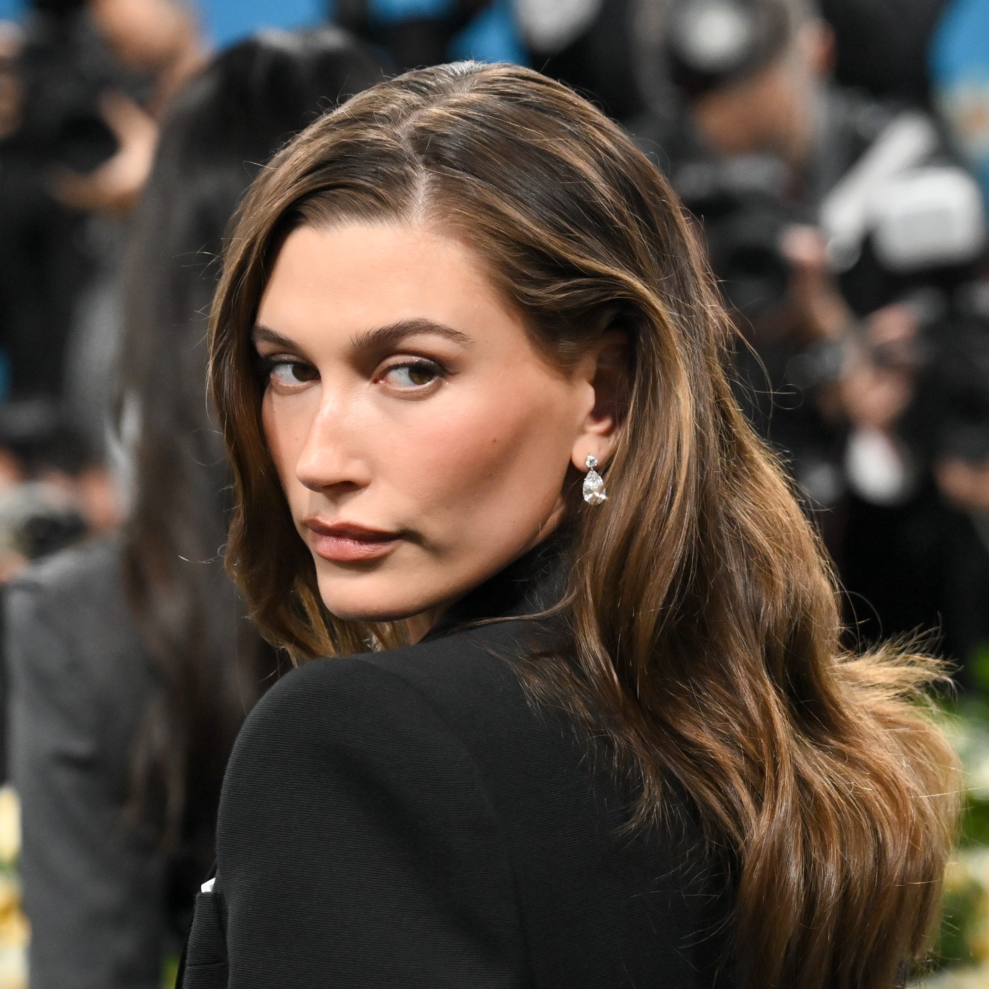 Hailey Bieber posing with her hair highlighted.