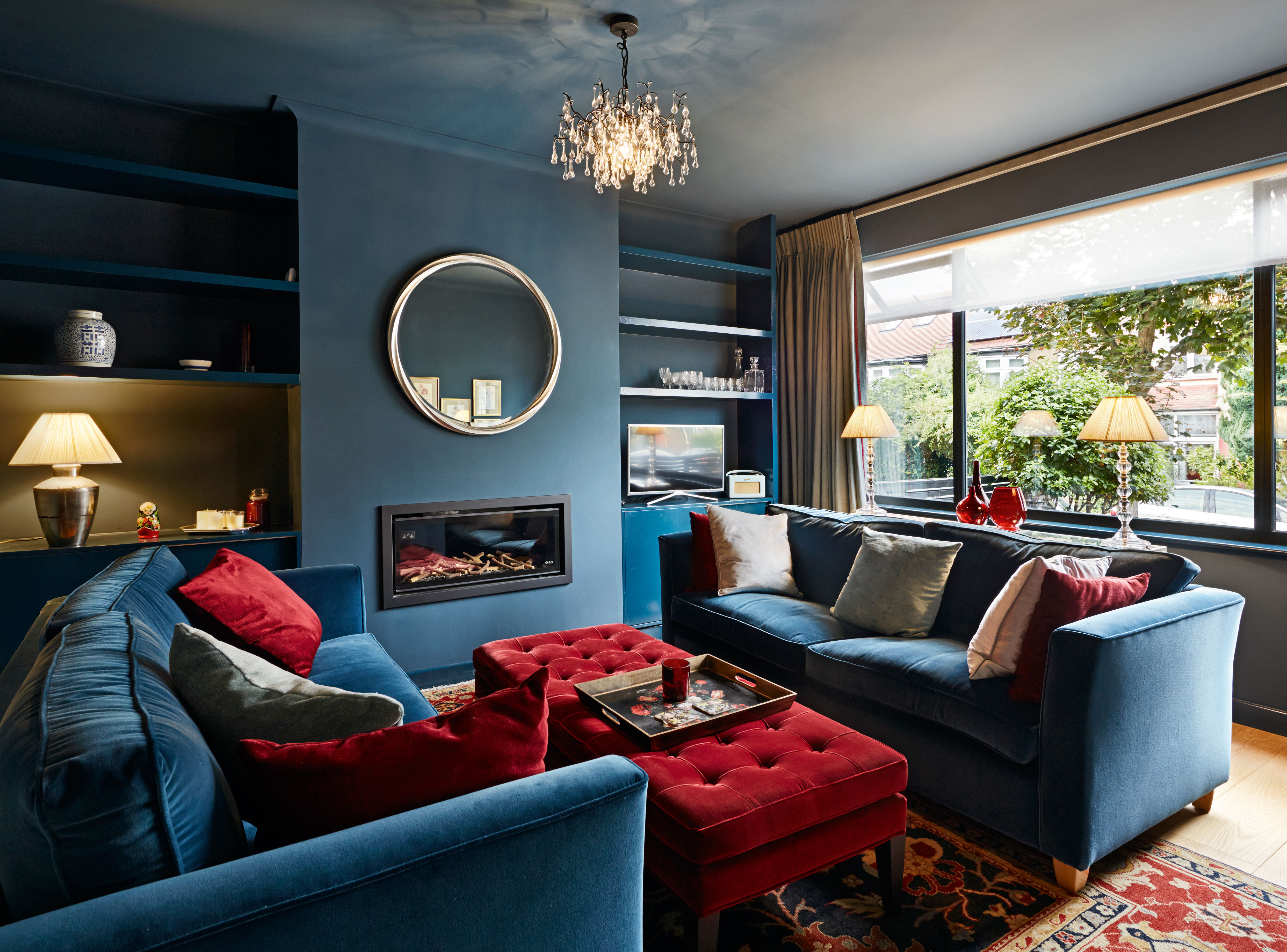 living room with deep blue inky scheme and other deeo red accents by mulroy architects