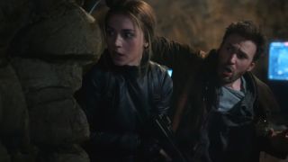 Ana de Armas and Chris Evans anxiously look around a corner in Ghosted.