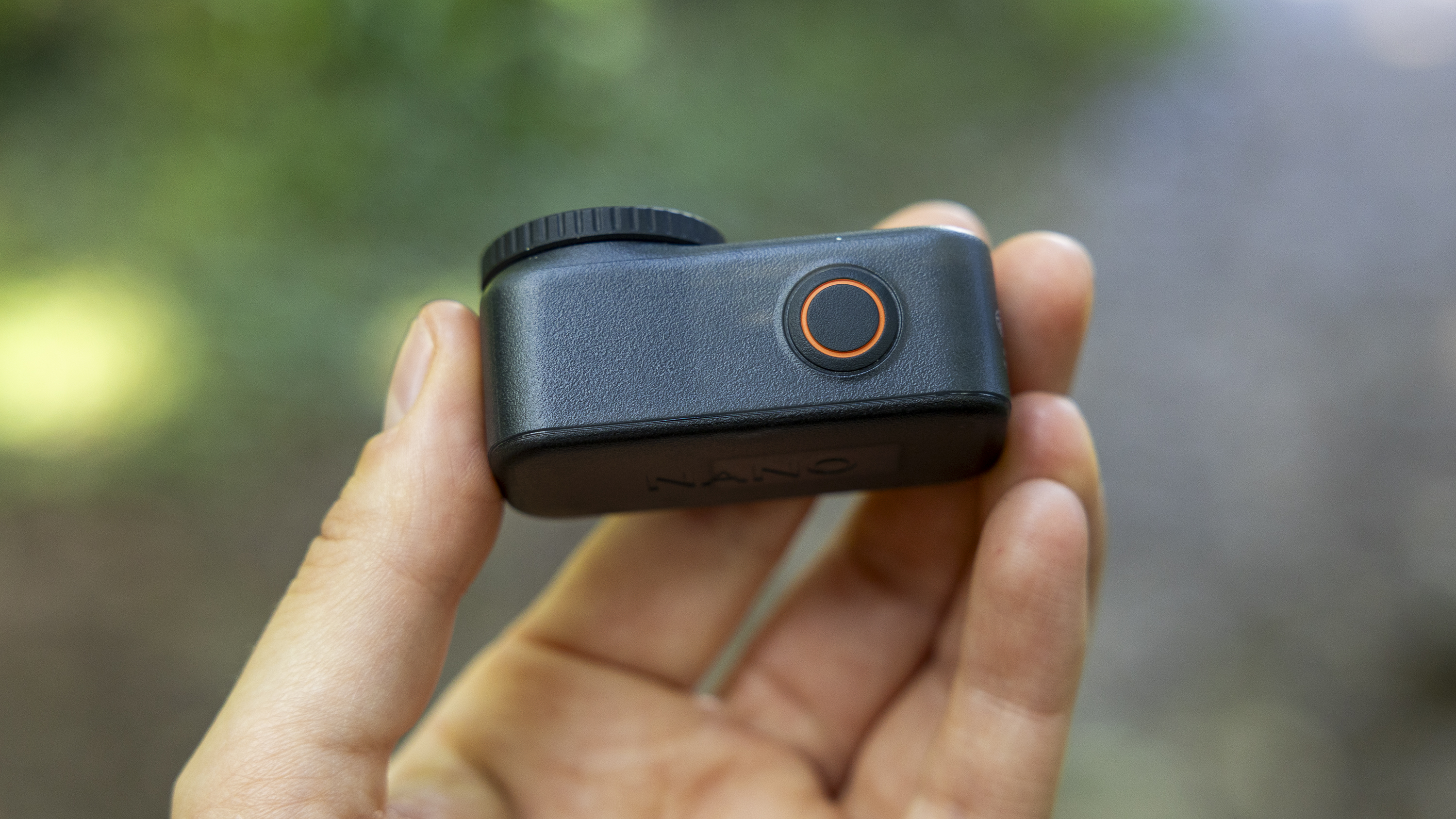 A female photographer holding the DJI Osmo Nano action camera