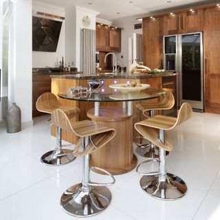 dinning area with round glass table top wooden bar stools