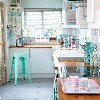 kitchen with pink accessories and white tiles