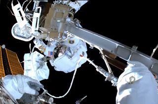 NASA astronaut Raja Chari, as seen from the helmet cam worn by European Space Agency (ESA) astronaut Matthias Maurer, works to install a new high definition video camera and wireless communications port during a spacewalk outside of the International Space Station on Wednesday, March 23, 2022.