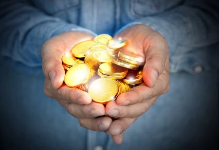 Hands holding gold coins.