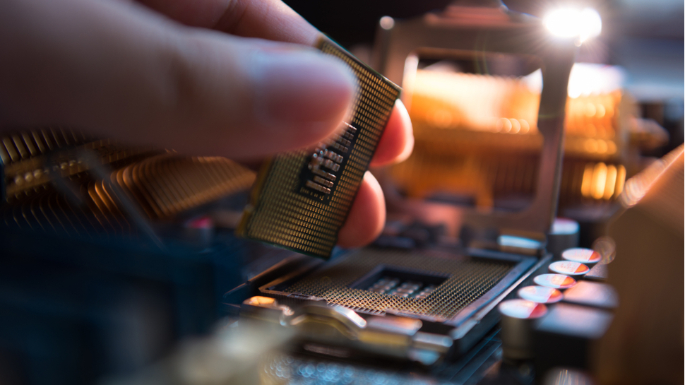 person installing a CPU into a motherboard