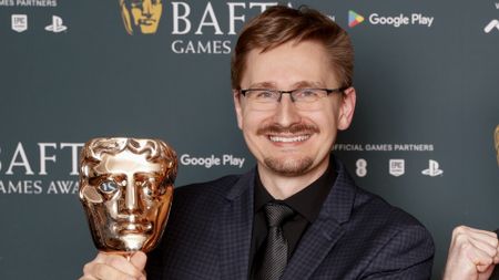 Prokop Jirsa holds a Bafta award while smiling.