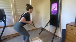 The author using the Tonal workout equipment at her home