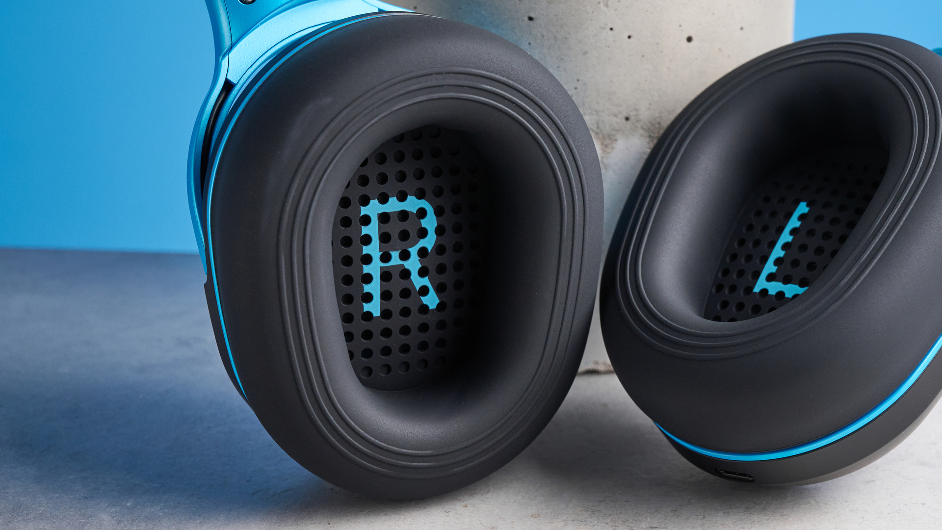 H2O RIPT Ultra headphones in black with blue accents photographed on a blue background
