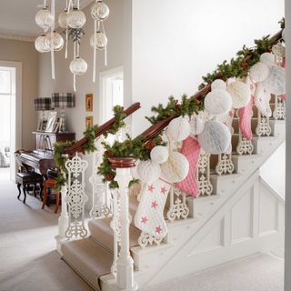 traditional hallways decorated for Christmas with garland, stockings and paper baubles