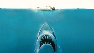 Poster for the movie Jaws. Here we see the head of a great white shark underneath the blue water. Just above the shark is an unsuspecting swimmer.