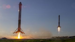 The two side first-stage boosters of SpaceX's Falcon Heavy rocket come back to Earth for a pinpoint landing shortly after launching the Arabsat-6A communications satellite on April 11, 2019.