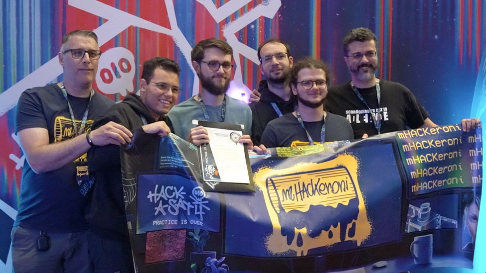 a team of people hold a trophy and a flag that reads &quot;hack-a-sat&quot;